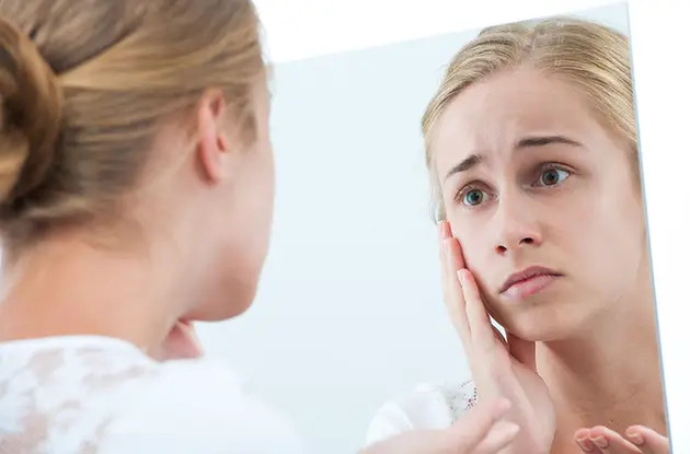 teen girl looking in mirror