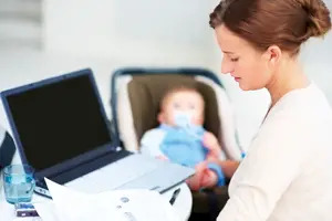 mom working from home; mother on laptop while caring for baby; busy mom