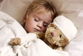 sick child sleeping with teddy bear
