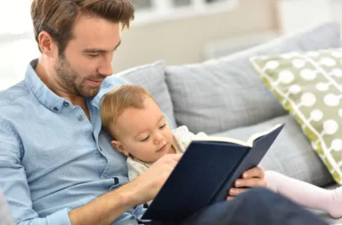 47872874 – father and child reading book in sofa