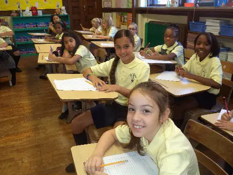 students writing at st joseph the worker catholic academy