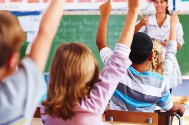 students-in-classroom-raising-hands