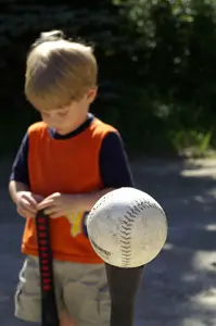 young boy playing t-ball; tee ball; little boy upset from losing baseball game