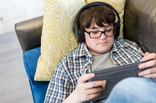 teenage boy with headphones using tablet