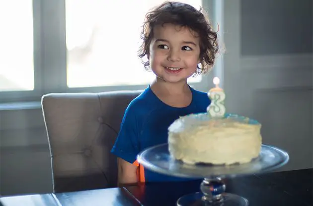 boy with birthday cake and three candle