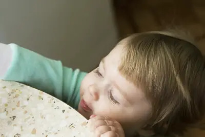 toddler reaching up onto table; small girl reaching for something on top of table