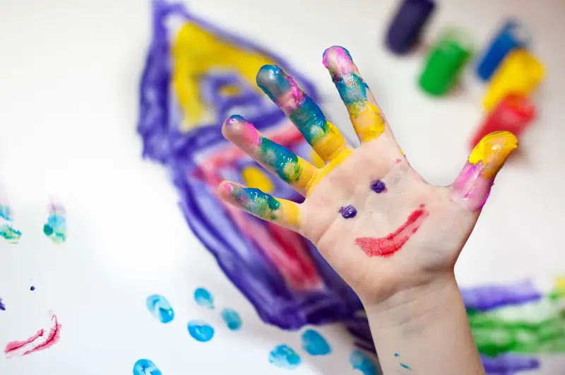 child's hand covered in finger paint