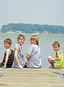 young boys sitting on a dock; children; bay