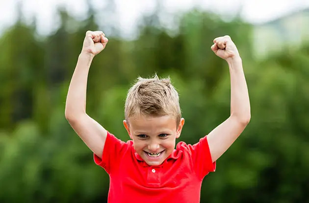 young boy raises arms