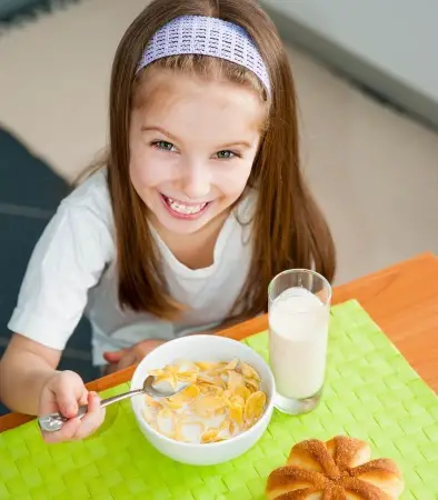 young girl eating breakfast