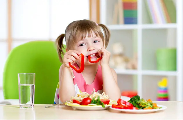 little girl eating vegetables