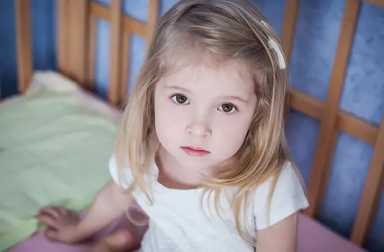 young-girl-looking-concerned-sitting-in-bed