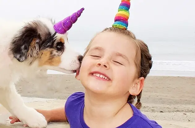young girl with puppy wearing unicorn horns