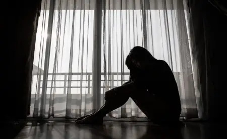 young woman sitting in dark room