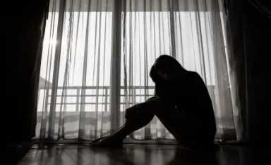 young-woman-sitting-in-dark-room