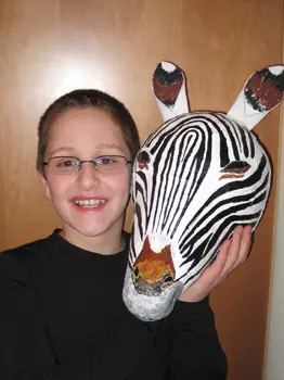boy holding zebra mask