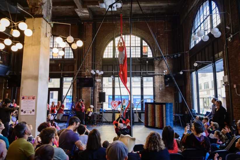 Circus performer using silks in front of an audience.