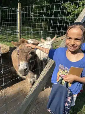 lif-family-fun-long-island-game-farm-expands-Petting -a donkey- Camp Zoo-courtesy-2024-05