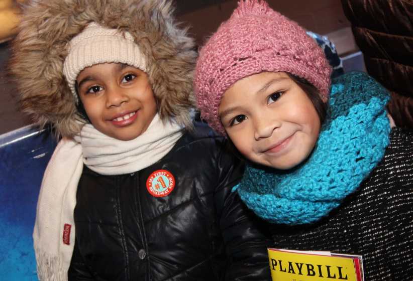 Two girls in winter jackets getting ready for Kids' Night on Broadway.