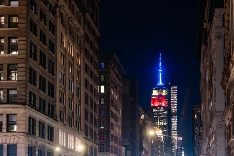 Empire State Building is illuminated at night in New York City.