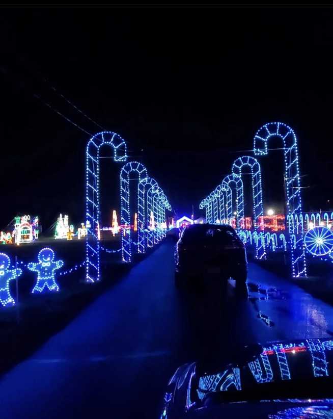 Cars driving through LED candy cane lined road. 
