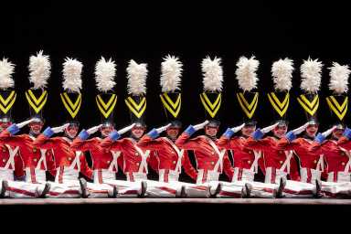 The Radio City Rockettes dancing on stage and dressed as toy soldiers