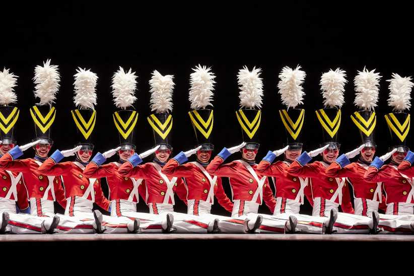 The Radio City Rockettes dancing on stage and dressed as toy soldiers