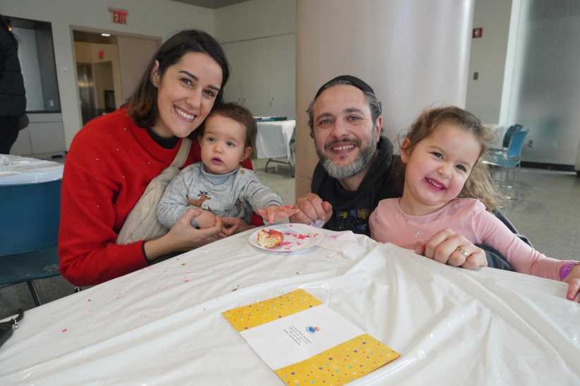 Mother, Father, infant, and toddler sitting around a table making crafts