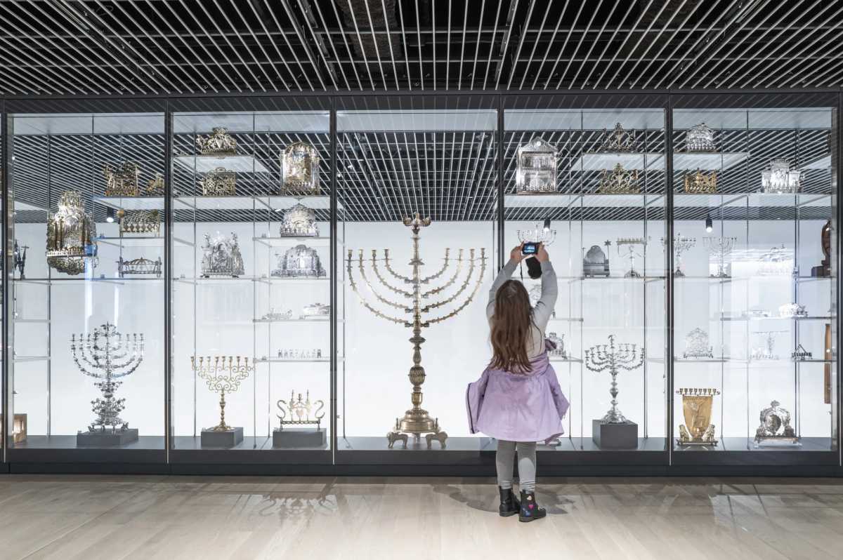 Little girl taking photo of Hanukkah Menorah display