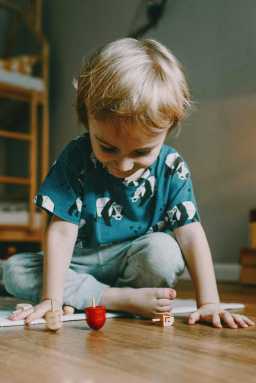 little boy spinning a dreidel on Hanukkah
