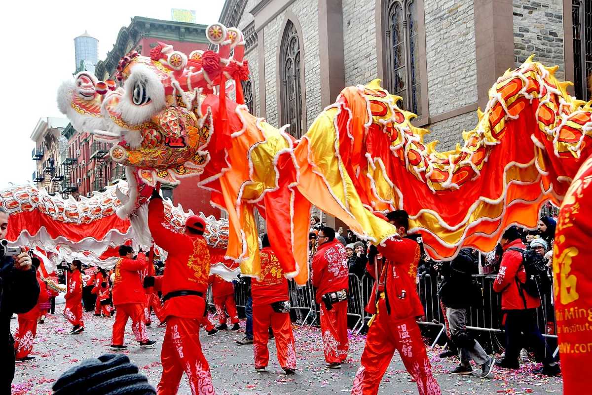 Dancers dressed in red holding a traditional lion for the Lunar New Year Lion Dance.