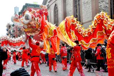Dancers dressed in red holding a traditional lion for the Lunar New Year Lion Dance.