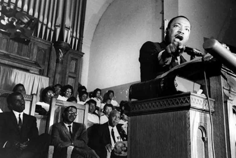 Dr. Martin Luther King, Jr. standing at a podium making a speech.