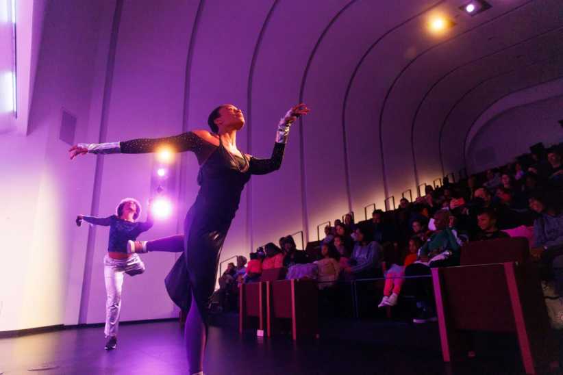 2 dancers performing in front of an audience of families.