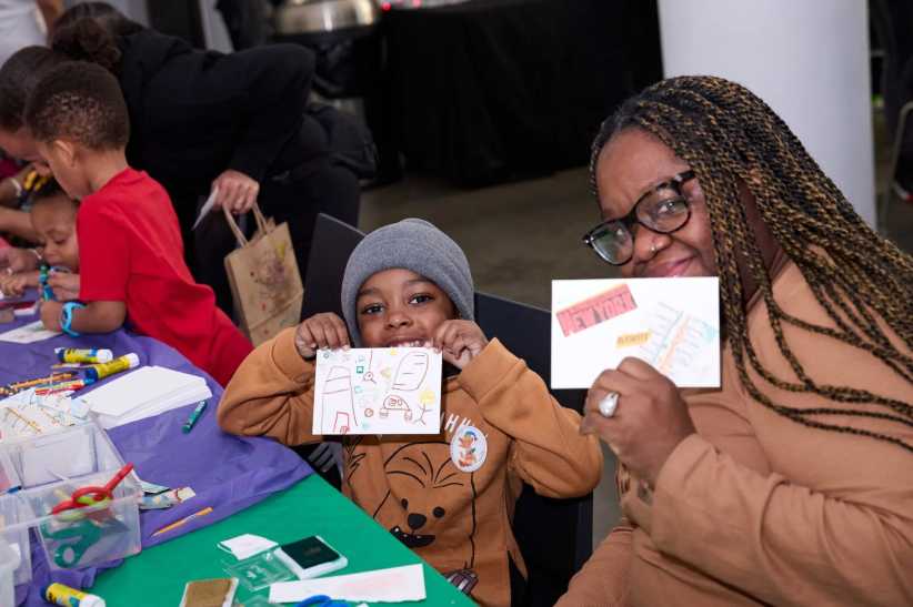 Mother and son holding up art that they made. 