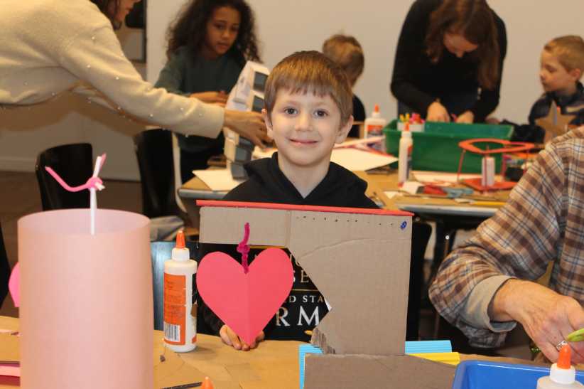 Child sitting a table making crafts