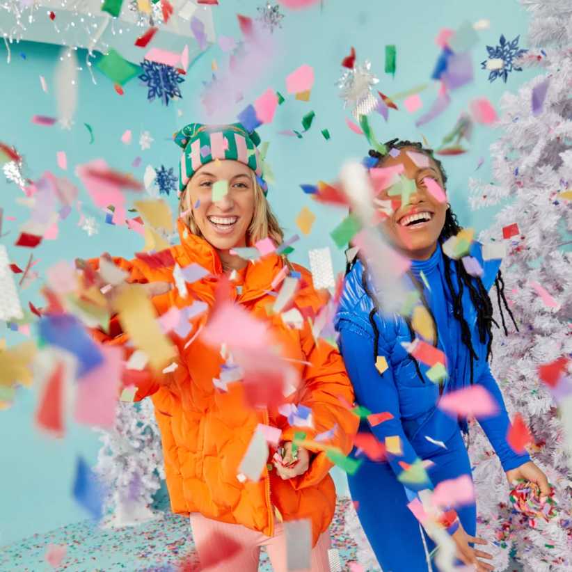 two women throwing paper confetti.