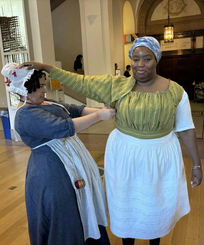 Two historical reenactors wearing historical clothing of 18th century female slaves.