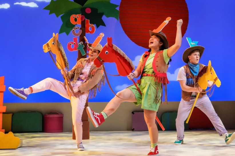 Three actors on stage performing Chicka Chicka Boom Boom: The Musical