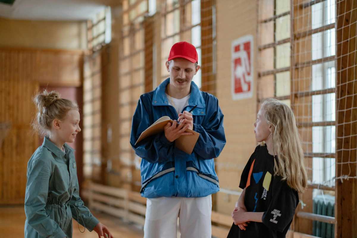 Coach with students in the gymnasium.