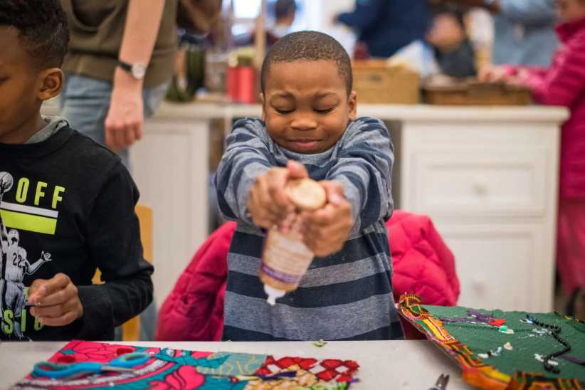 Little boy squeezing glue on to a craft.