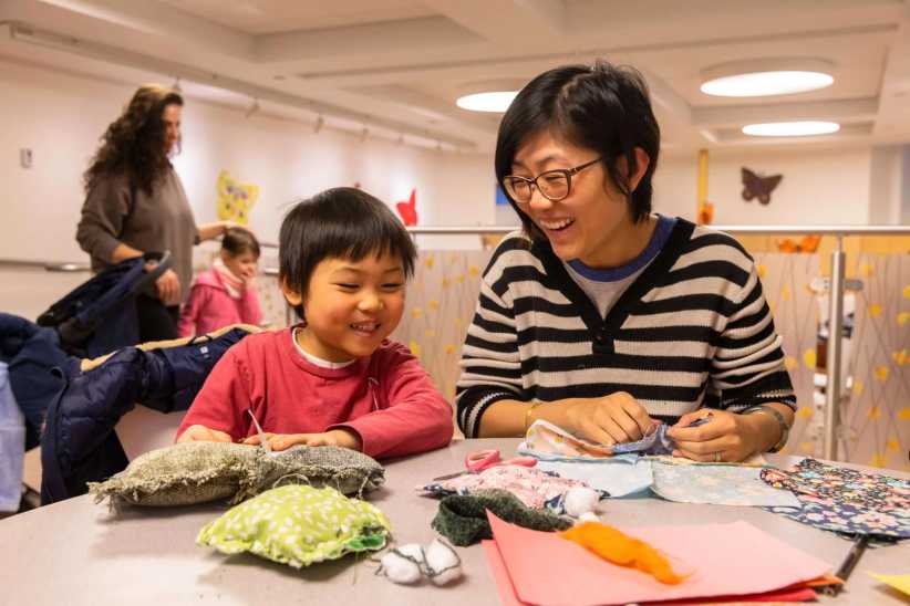 Mothe rand child laughing together while working on a craft. 