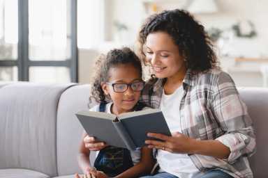 African-american mother mom reading book novel with daughter girl, 16 Must-Read Books for All Ages to Celebrate Women’s History Month