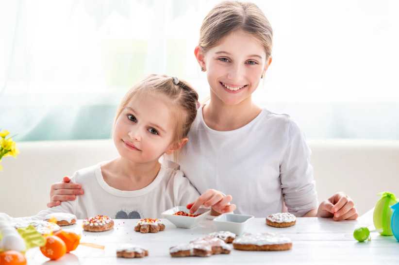 Two Little Girls Decorating Gingerbread Cookies For Easter, Skip the Dye Kit This Easter — These 3 Ideas Are Way More Fun