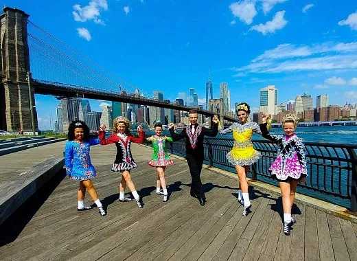 Irish step dancers performing in front of the brooklyn bridge