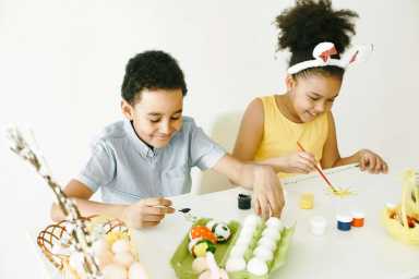 boy and girl painting easter eggs together
