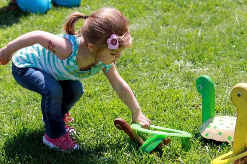 Little girl playing a game on the grass.