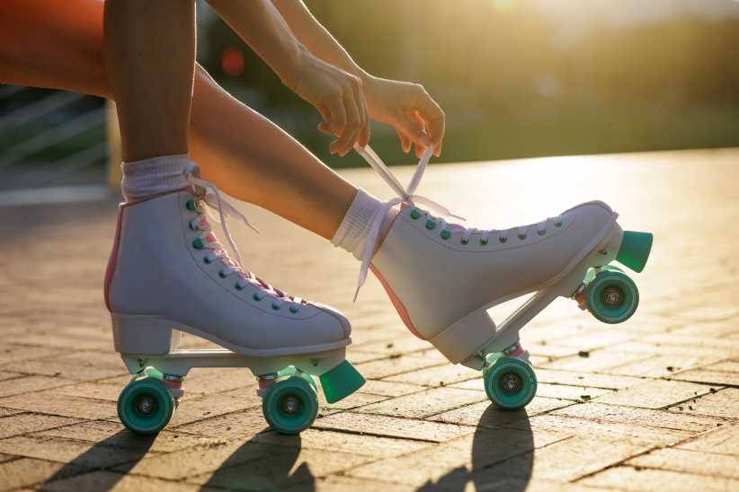 Hands lacing up roller skates to enjoy the Best Rinks to Go Roller Skating on Long Island