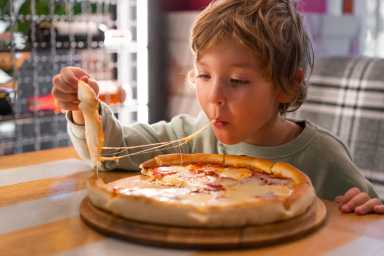 Cute boy eating a piece of pizza, Yelp Top 100 Places to Eat, best places to eat in nyc