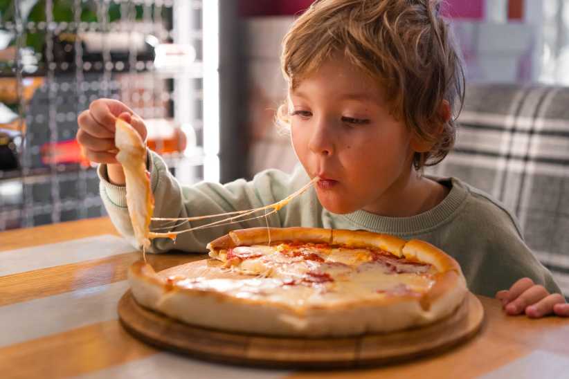 Cute boy eating a piece of pizza, Yelp Top 100 Places to Eat, best places to eat in nyc